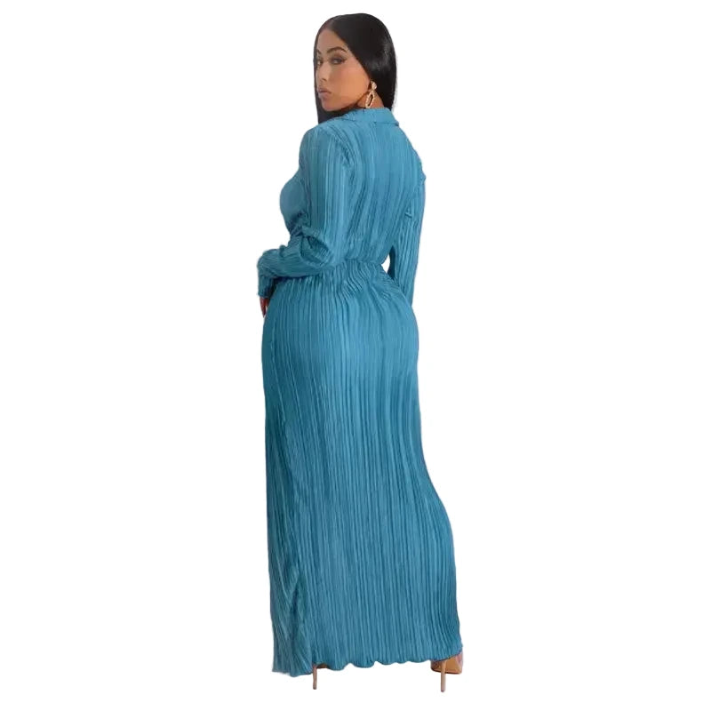 Woman wearing a teal pleated dress against a white background