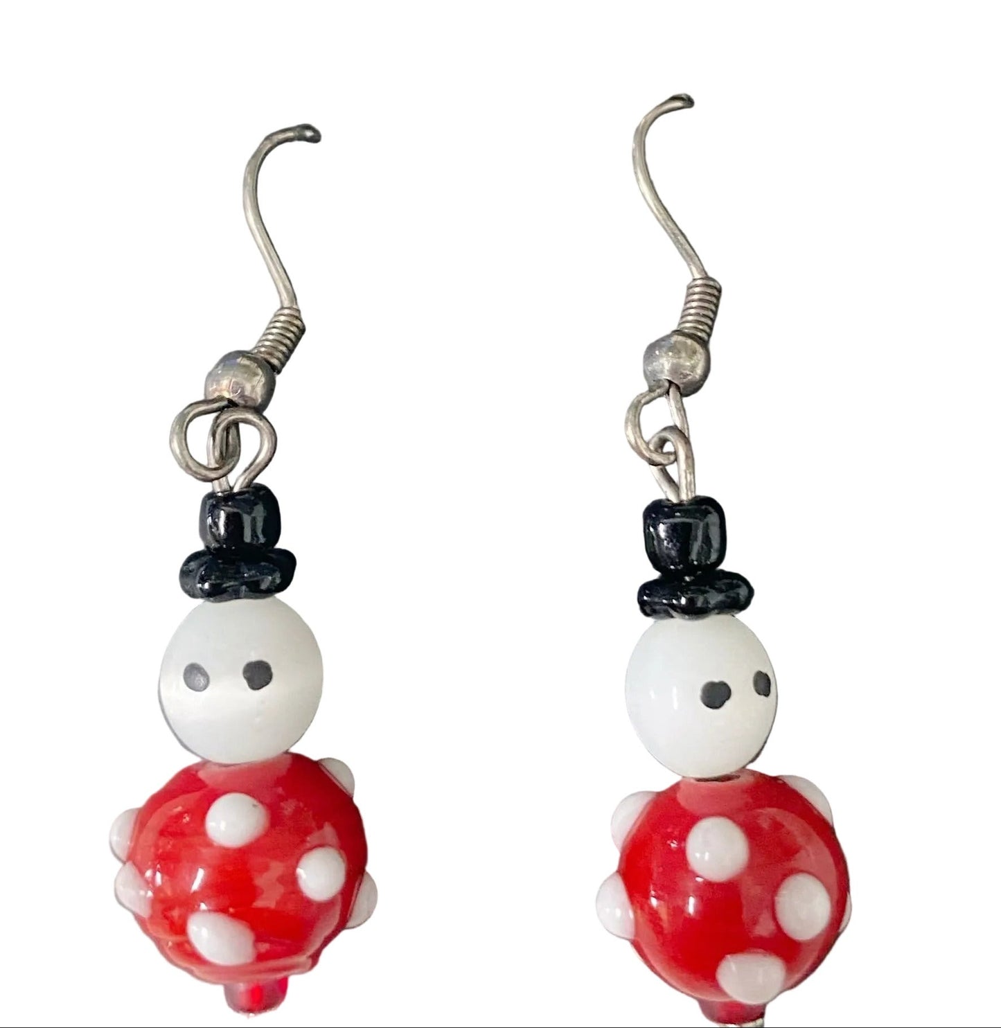 A pair of earrings featuring a snowman and Santa Claus designs, primarily red and white in color, with gold accents.