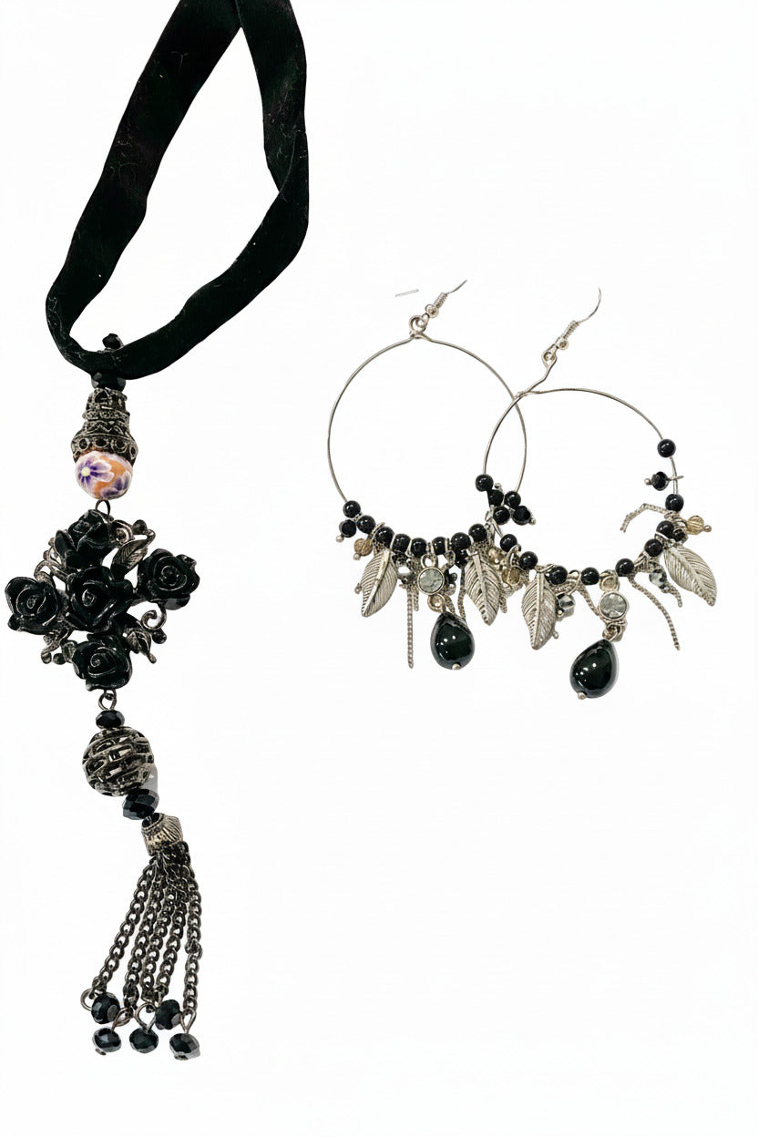 A black velvet chain lariat necklace with a floral design and a pair of matching earrings, displayed on a hanger.