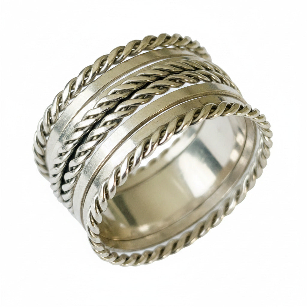 A silver cuff bracelet with spiral patterns, displayed against a white background.
