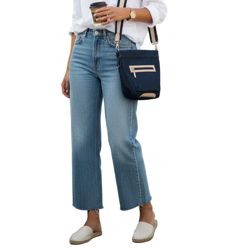 Blue denim handbag with gold accents on a white background