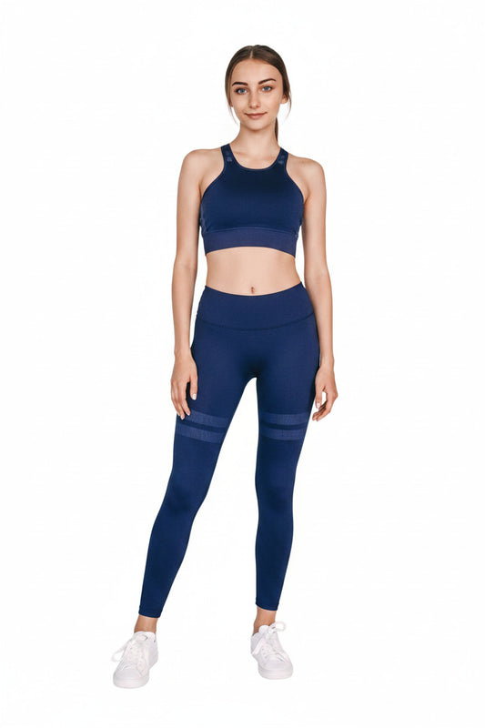 Woman wearing a two-piece blue athletic outfit sitting on a white background