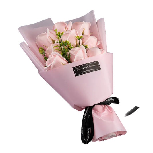 Bouquet of pink flowers wrapped in pink paper with a black ribbon on a black background