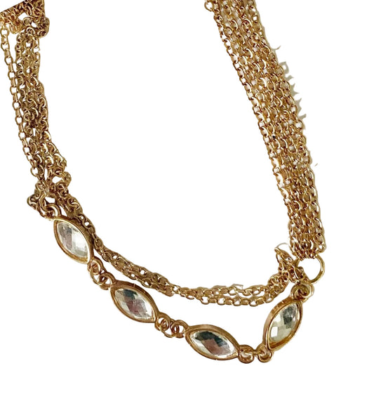 Gold chain necklace with embedded stones on a white background