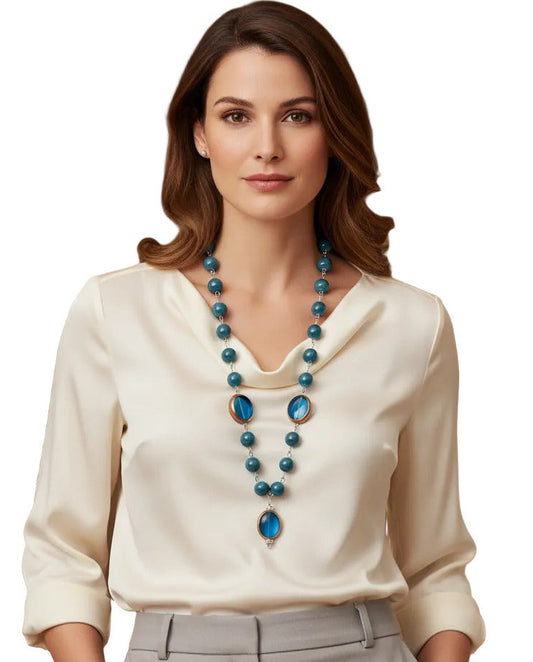 A beaded necklace featuring marbled teal blue beads and two large oval blue glass inserts with gold-toned metal trim, shown against a plain white background.