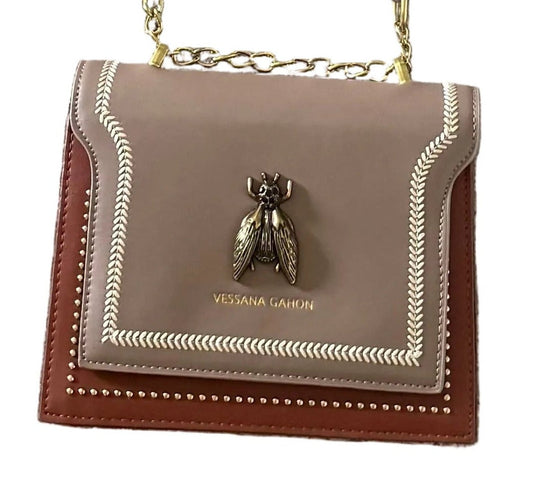 A small Vessana Gahon shoulder bag in taupe and brown leather with gold-tone chain strap and a bee hardware accent on the front flap, shown against a plain white background.