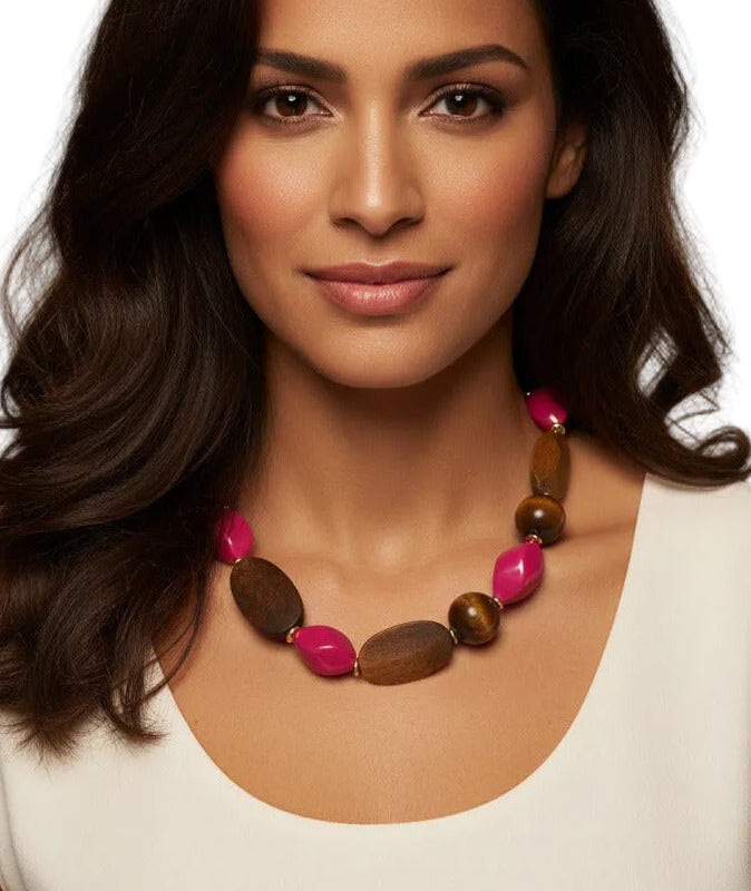 A beaded necklace featuring natural brown wood beads, faceted pink glass beads, and small gold spacer rings, displayed on a clean white background.