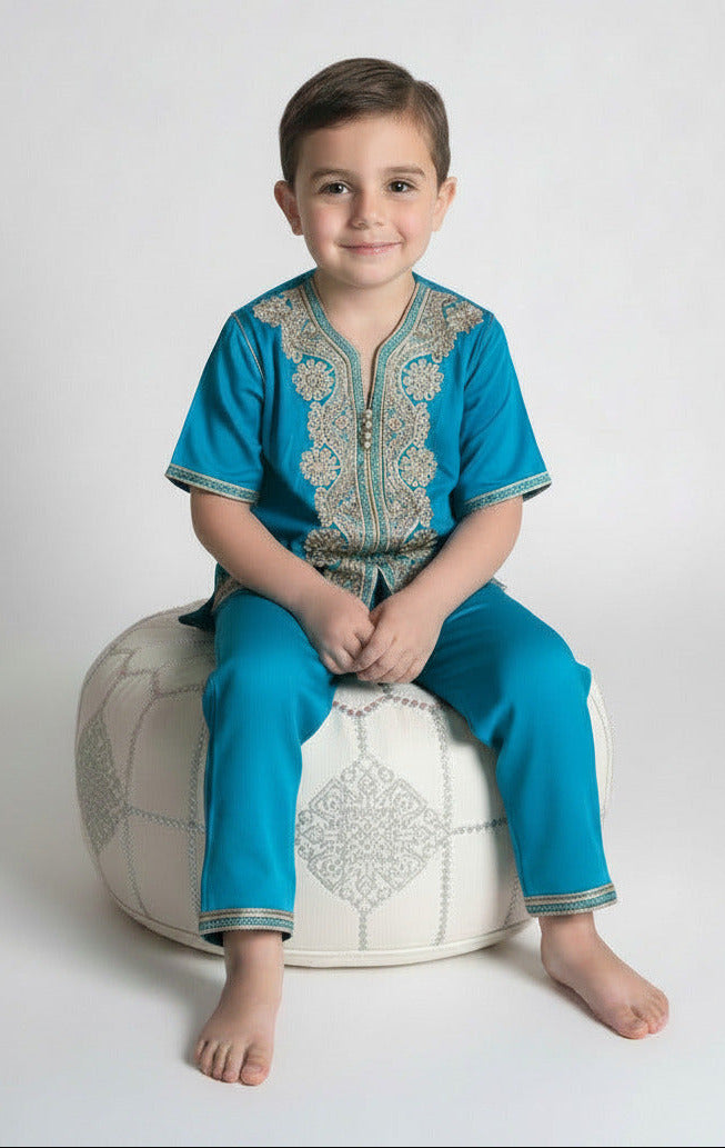 Child wearing a blue embroidered shirt on a white background