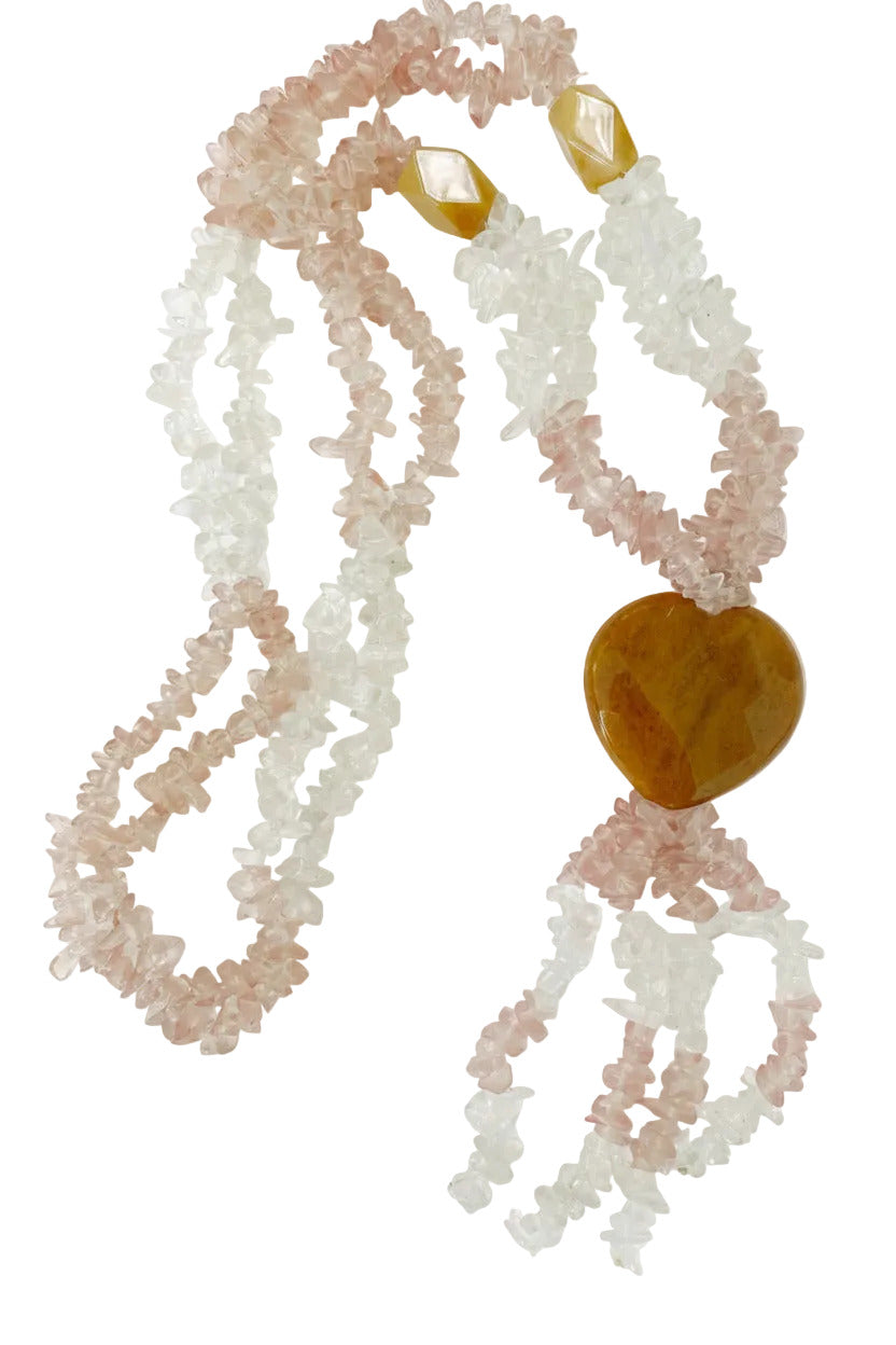 A crystal necklace featuring strands of light pink and white quartz chips with a polished amber heart-shaped bead and small faceted amber beads at the top, set against a plain white background.