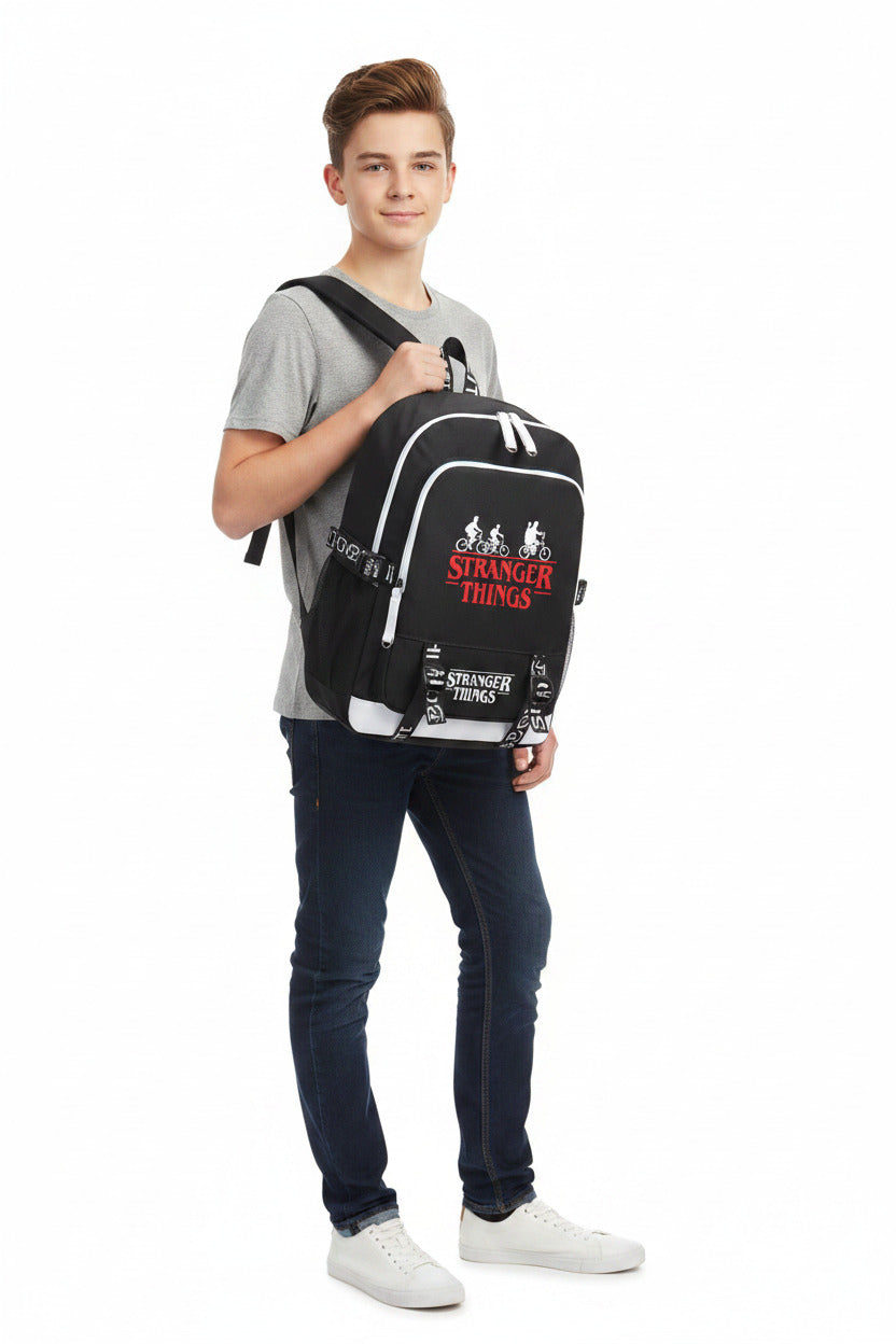 A black backpack featuring the red and white 'Stranger Things' logo and graphic on the front pocket, with white piping and adjustable black side straps.