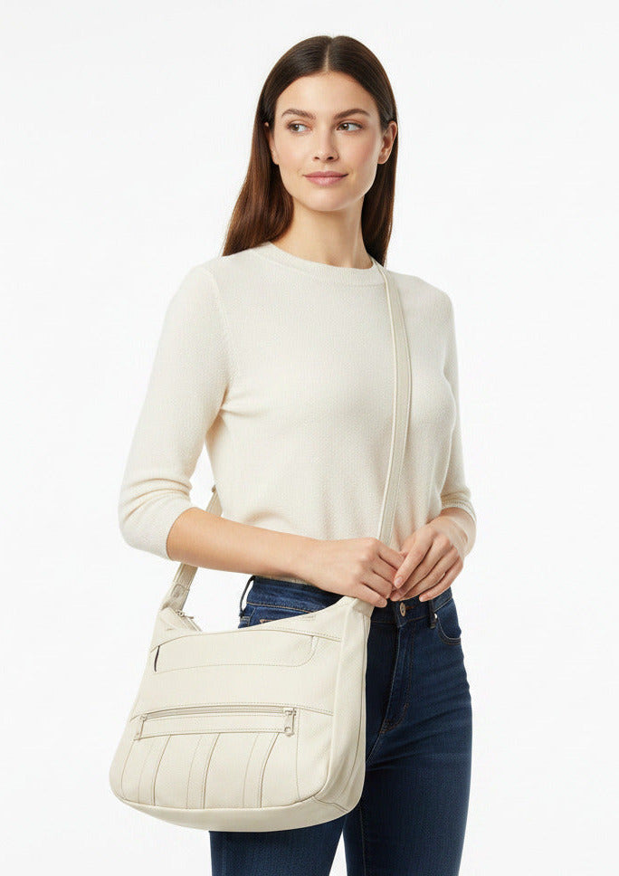 An off-white faux leather shoulder bag with multiple zippered pockets and a long shoulder strap, shown against a plain white background.