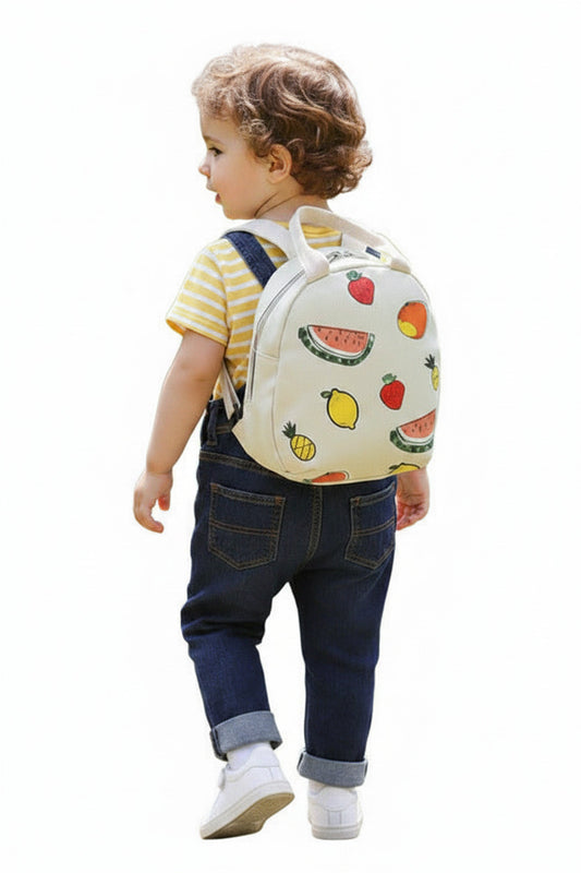 A kid carrying a cream small round bag with fruit patterns on a white surface.