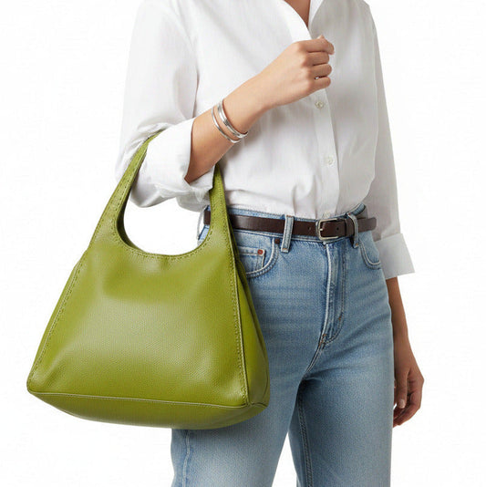 A woman holding a green leather handbag on a light gray background