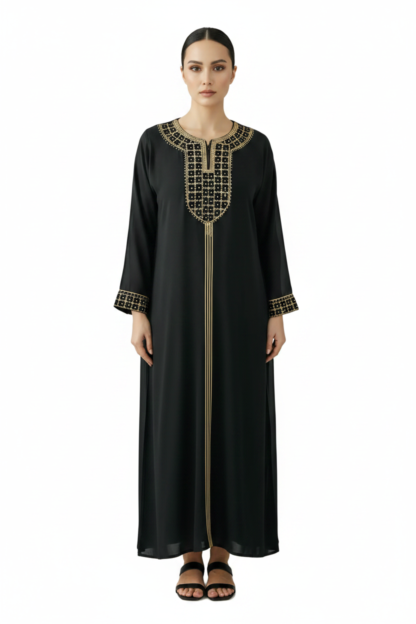 Woman wearing a black dress with gold embroidery against a gray background