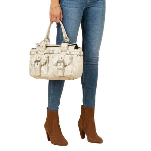 An off-white faux leather handbag with multiple front flap pockets, silver-tone buckle details, and a top handle, shown against a plain white background.