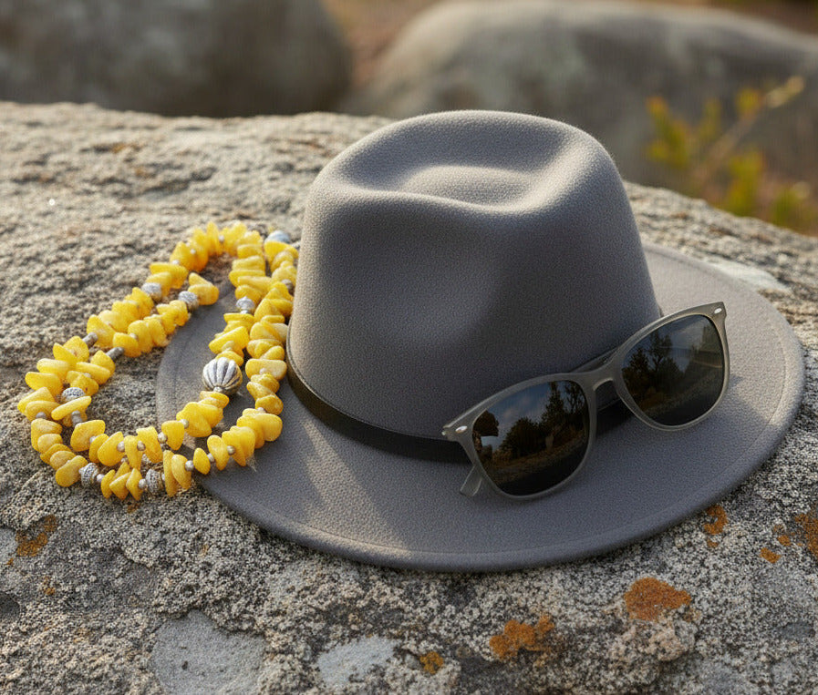 Necklace with yellow beads and silver accents on a white background