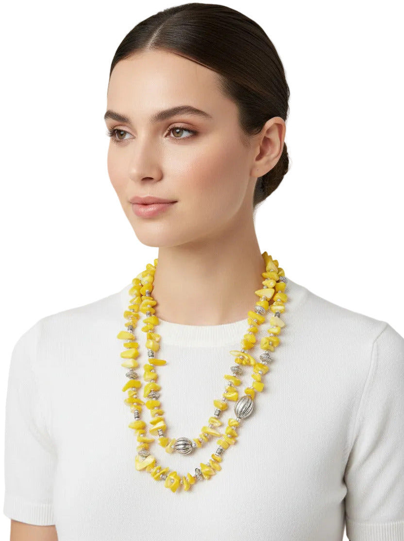 vintage handmade necklace with yellow beads and silver accents on a white background