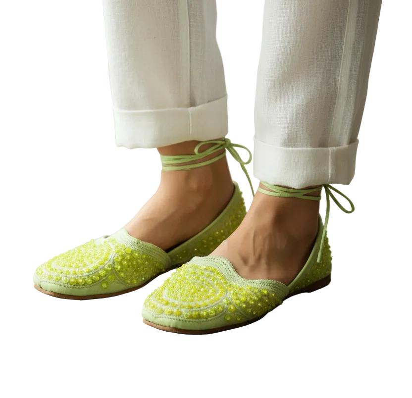 Pair of yellow sandals with decorative patterns on a white background