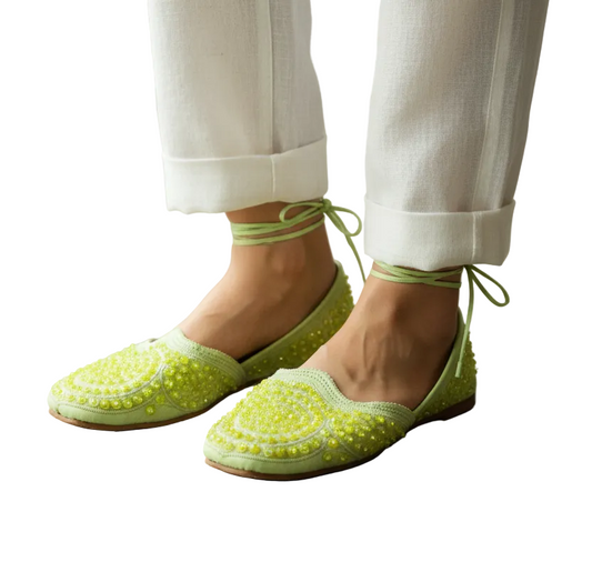 Pair of yellow sandals with decorative patterns on a white background