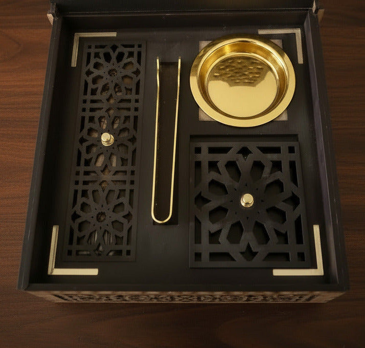 A traditional wooden incense burner set with intricate geometric cutouts, featuring a dark brown box, a gold color incense holder, and tong, shown open on a wood surface--TTP