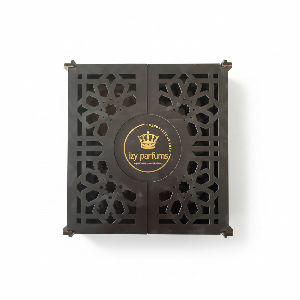 A square dark brown wooden box with intricate geometric cutout patterns on the front, featuring a circular logo in the center that reads 'Izy parfums'.